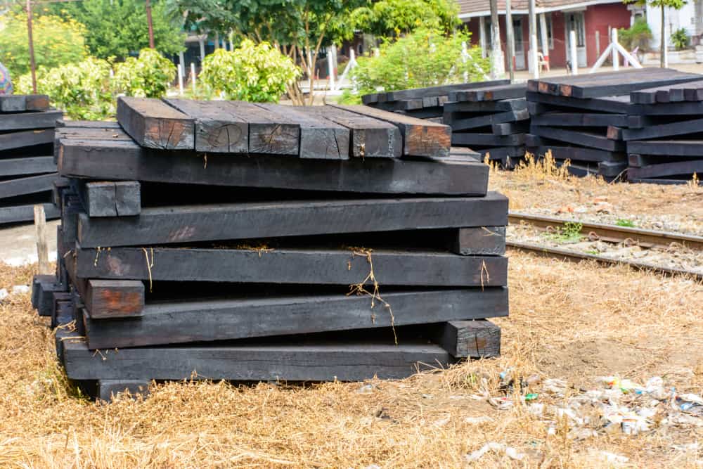 photo of wooden sleeper, pile up beside railroad